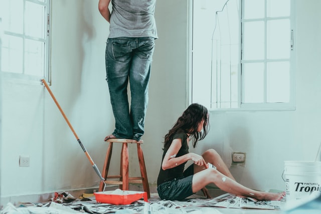 A couple painting the walls in their apartment.