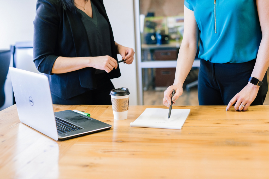 Two people standing by a wooden table