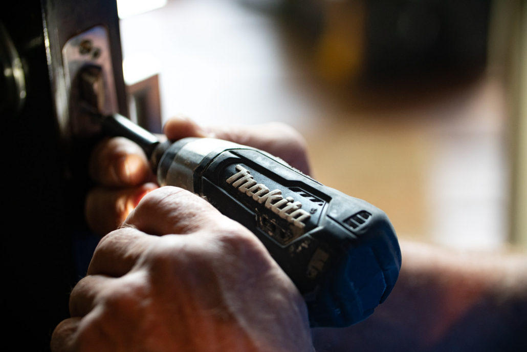 A man using a drill on a door