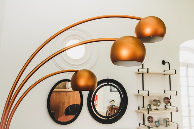 Brass-colored retro floor lamp with three lights in a living room