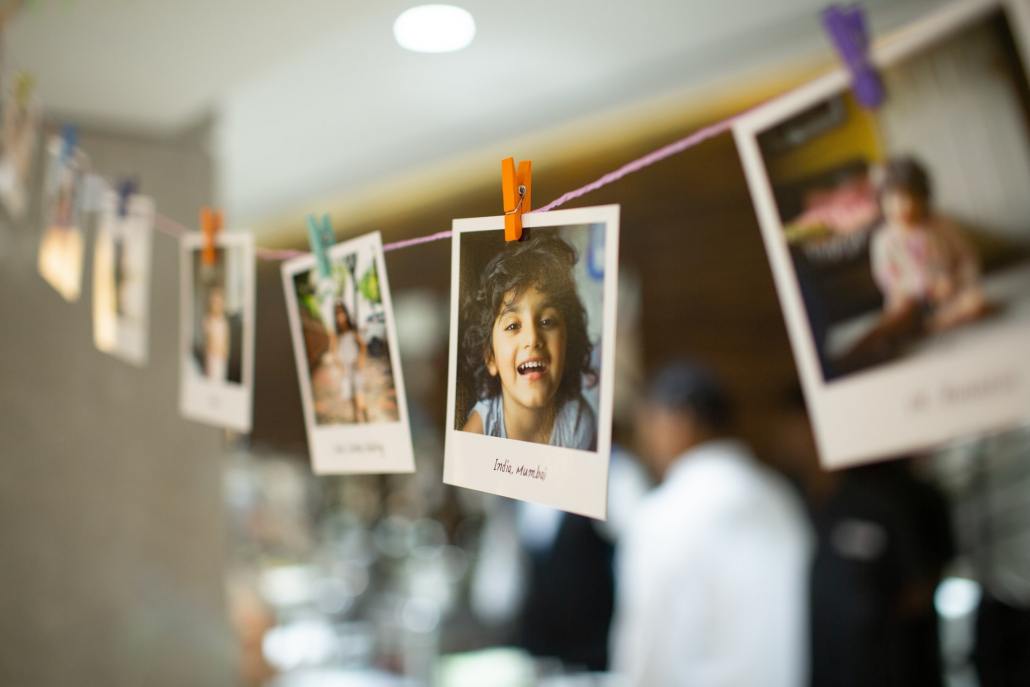 Polaroid pictures of various people hung on a string