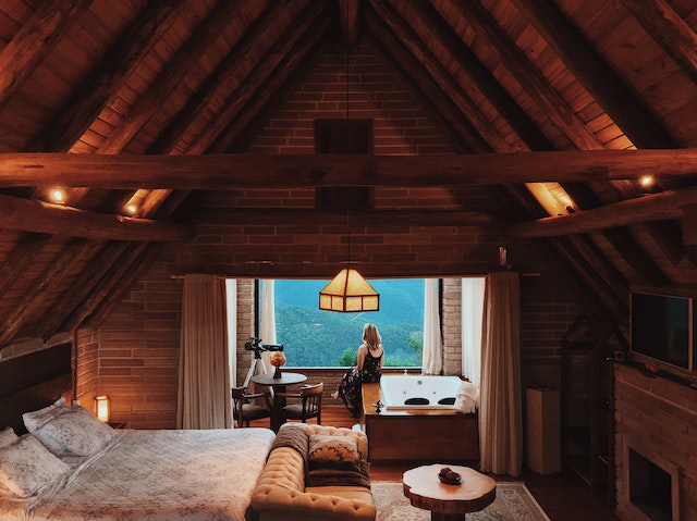 A large attic bedroom with seating and a bathing area. 