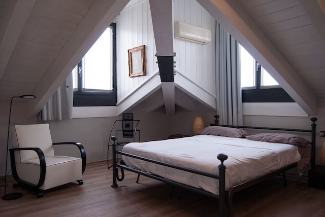 An attic bedroom with white walls and furnishings