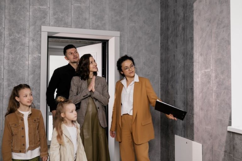 A real estate agent shows a house to a family.