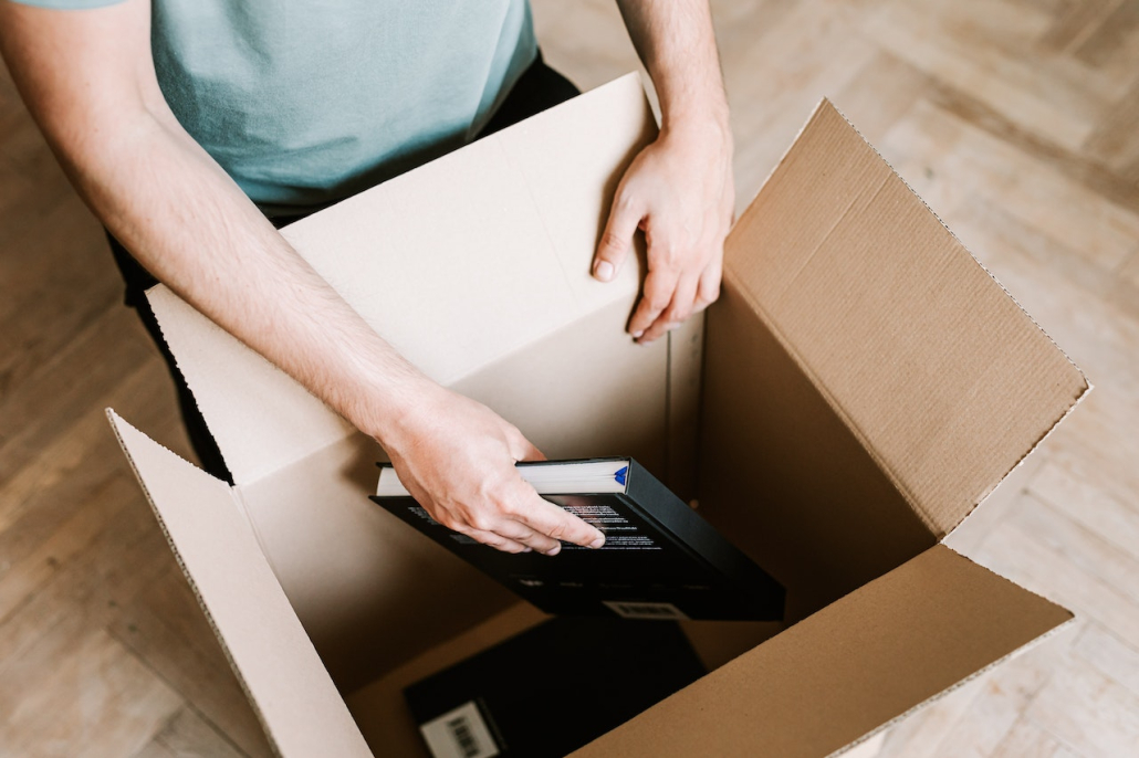 A man decluttering his book collection, something you can do to simplify your life when moving.