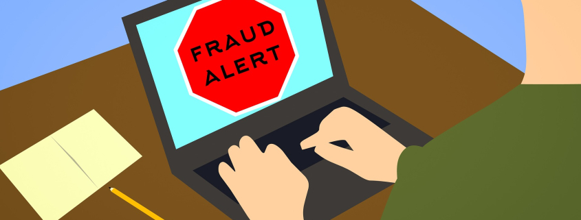 A person on a laptop that shows a red “fraud alert” sign for common international moving scams