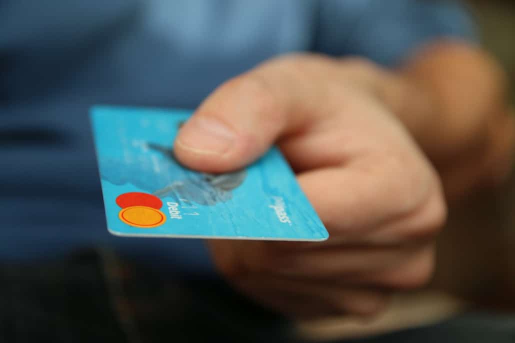 A person holding out a debit card