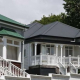 This is not the Global Financial Crash all over again » Team Davis Row of white wooden houses with wraparound porches and decorative trim, varying green/gray roofs in a sunny neighborhood